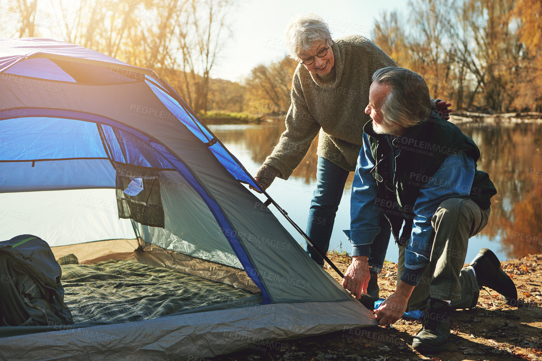 Buy stock photo Shot of a senior couple setting up a tent while camping in the wilderness