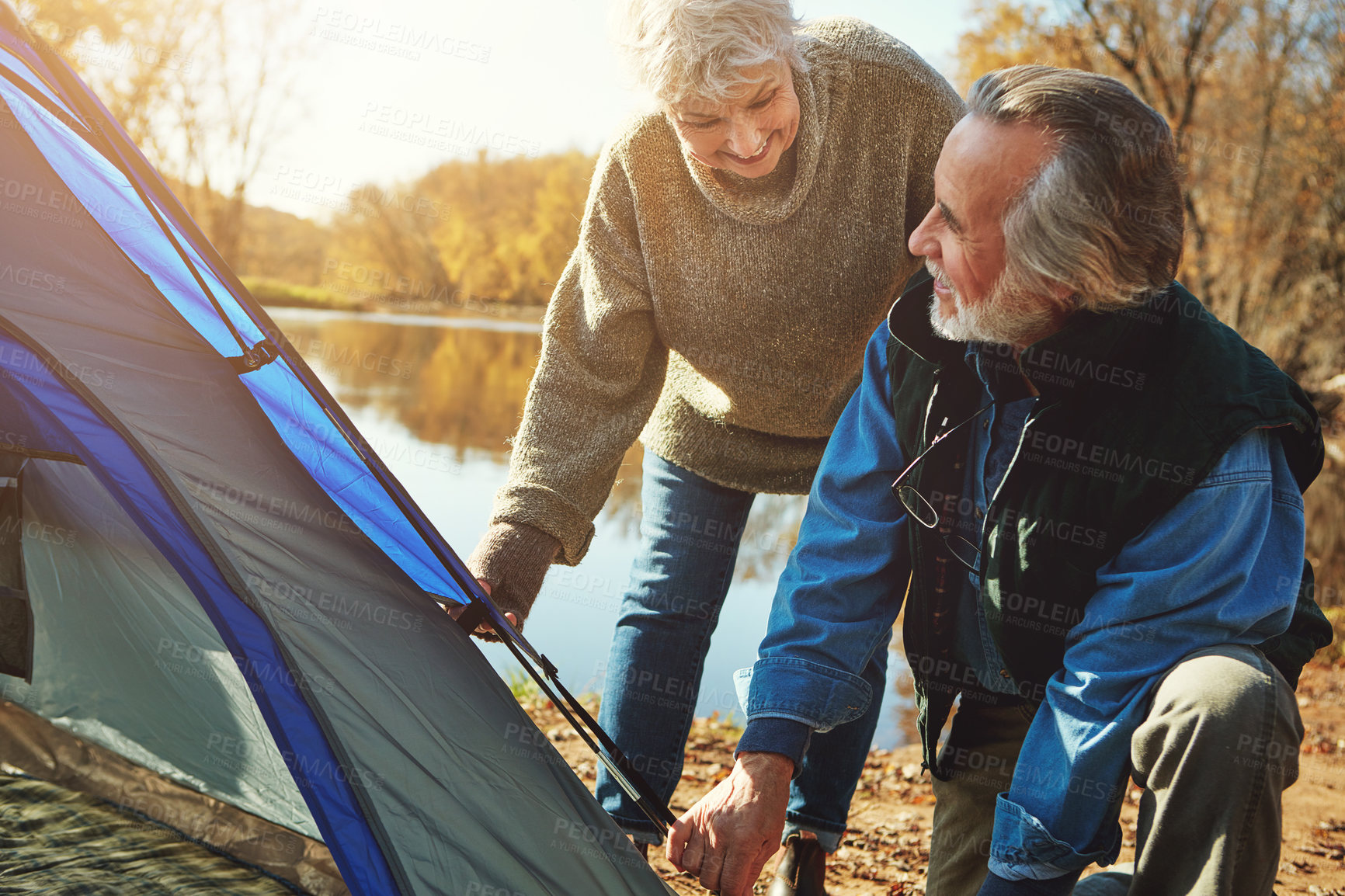 Buy stock photo Shot of a senior couple setting up a tent while camping in the wilderness