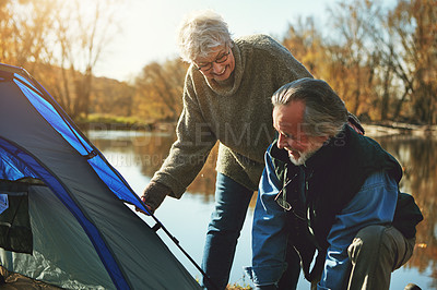 Buy stock photo Shot of a senior couple setting up a tent while camping in the wilderness