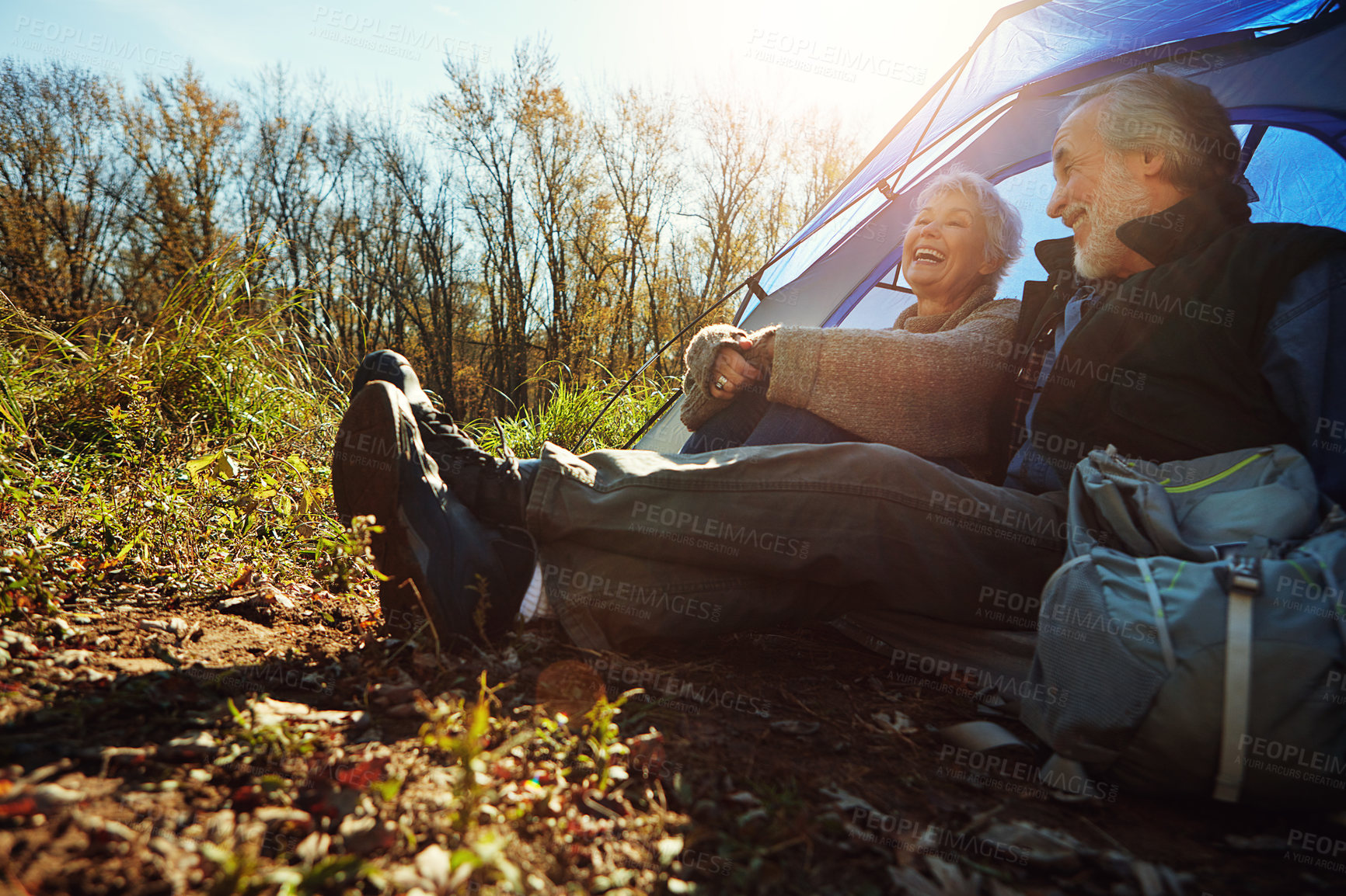 Buy stock photo Camping, laugh and old couple in woods for holiday, adventure and retirement journey. Senior people, tent and support at campsite with eco tourism, hobby and sunshine in countryside for vacation