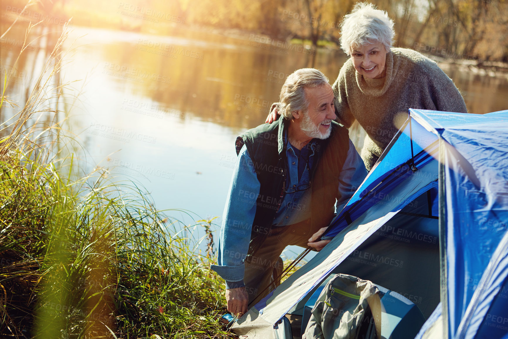 Buy stock photo Shot of a senior couple setting up a tent while camping in the wilderness