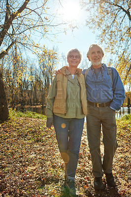 Buy stock photo Love, nature and senior couple in forest with backpack for walk, exercise and bonding together. Smile, travel and elderly man and woman in retirement enjoying view by woods in Autumn in England