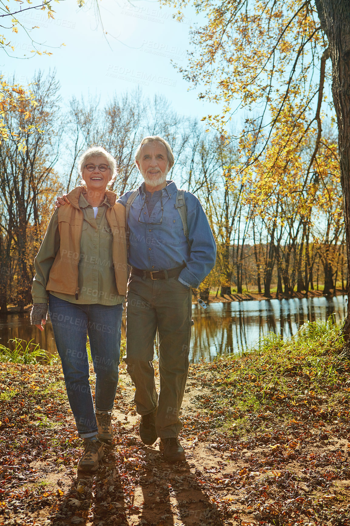 Buy stock photo Travel, nature and senior couple in forest with backpack for walk, exercise and bonding together. Happy, love and elderly man and woman in retirement enjoying view by woods in Autumn in England.