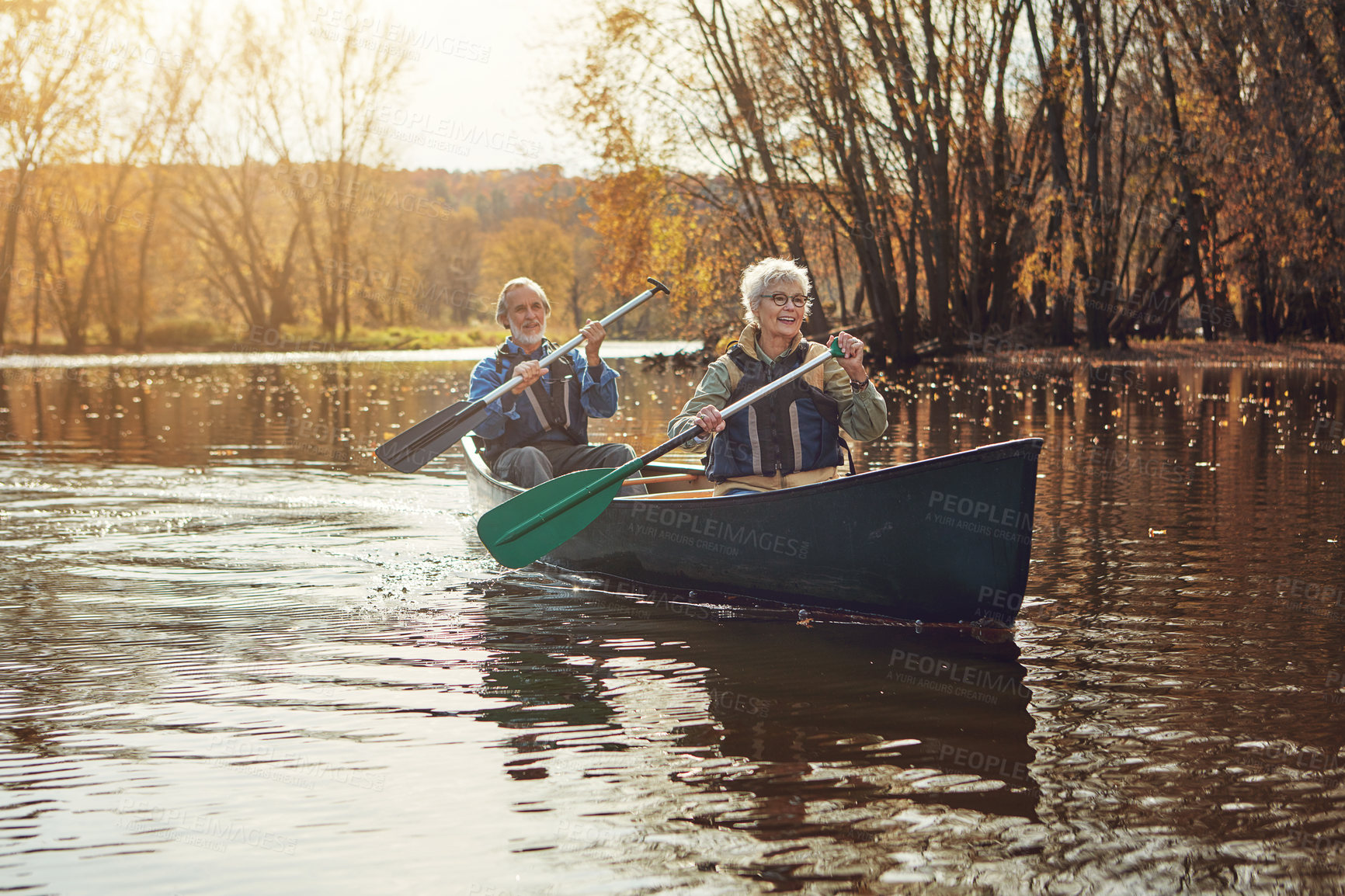 Buy stock photo Senior couple, kayak and rowing in lake for holiday, travel or summer vacation in water outdoor together. Man, woman and canoe boat in river on transport for adventure, exercise and smile in nature