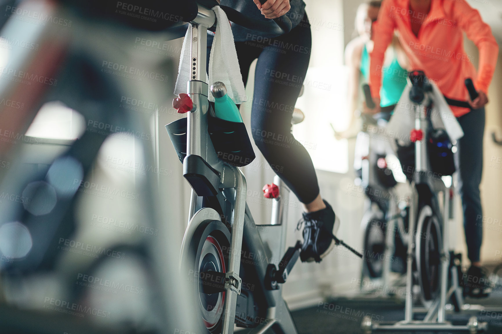 Buy stock photo Fitness, legs and exercise bike with people in a gym for a cardio or endurance spinning class workout. Health, wellness and energy with a sporty athlete group training or cycling in a sports center