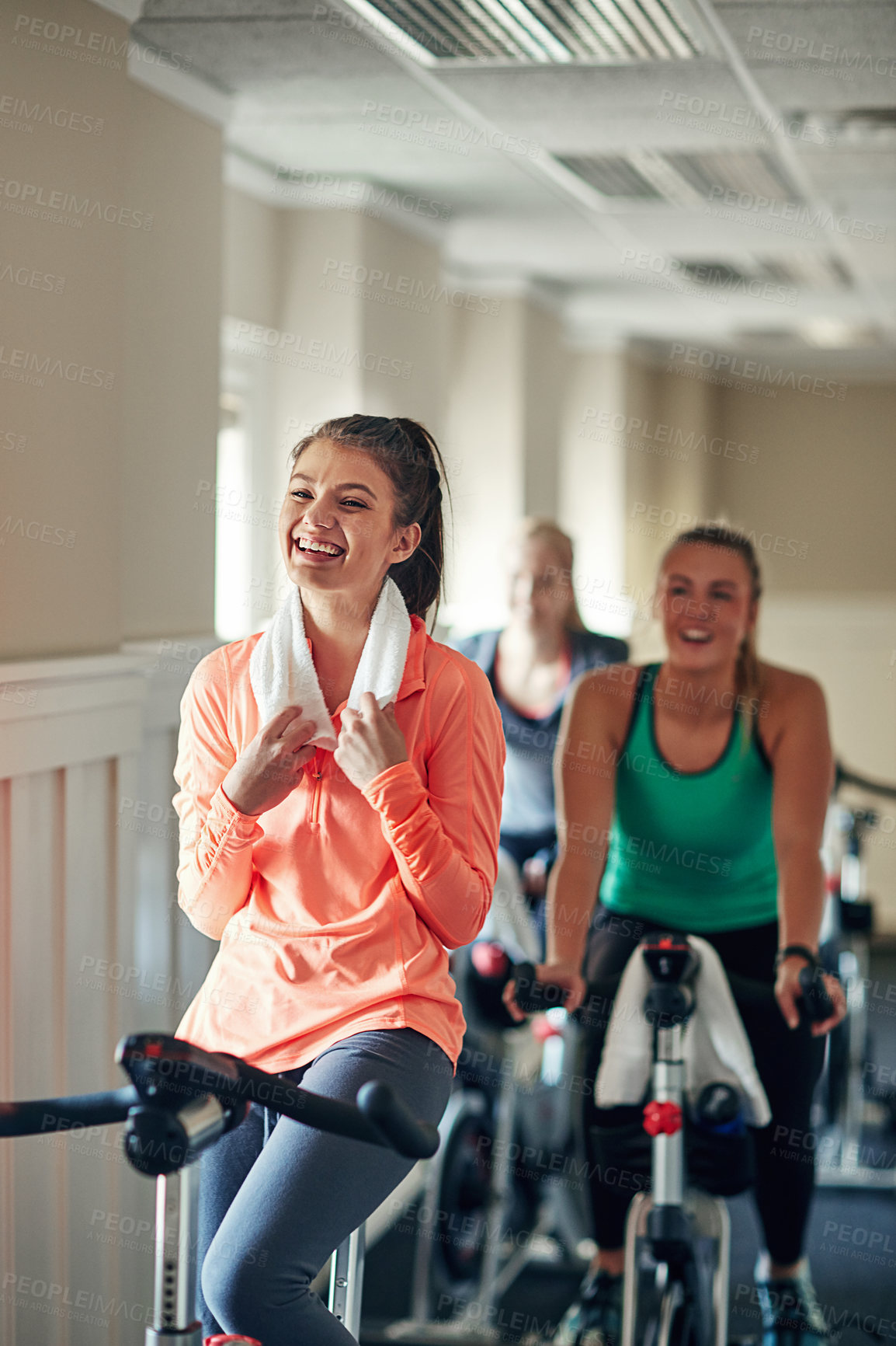 Buy stock photo Happy woman, cycling and towel with spin class for fitness, training or workout exercise at indoor gym. Active female person or group of cyclists with smile on equipment or bicycle at health club