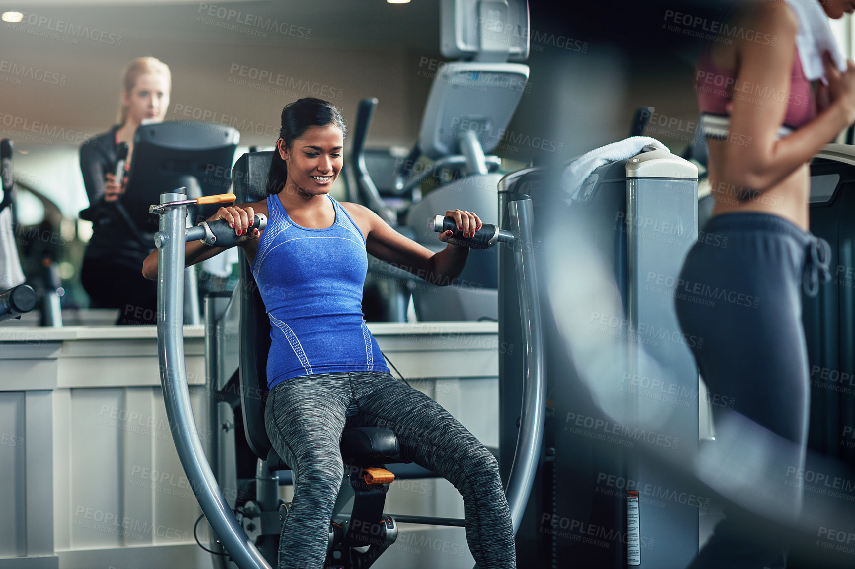 Buy stock photo Shot of a young woman working out with a chest press at a gym