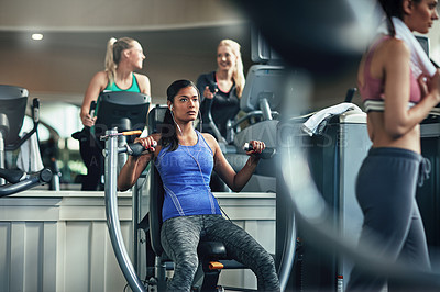 Buy stock photo Shot of a young woman working out with a chest press at a gym