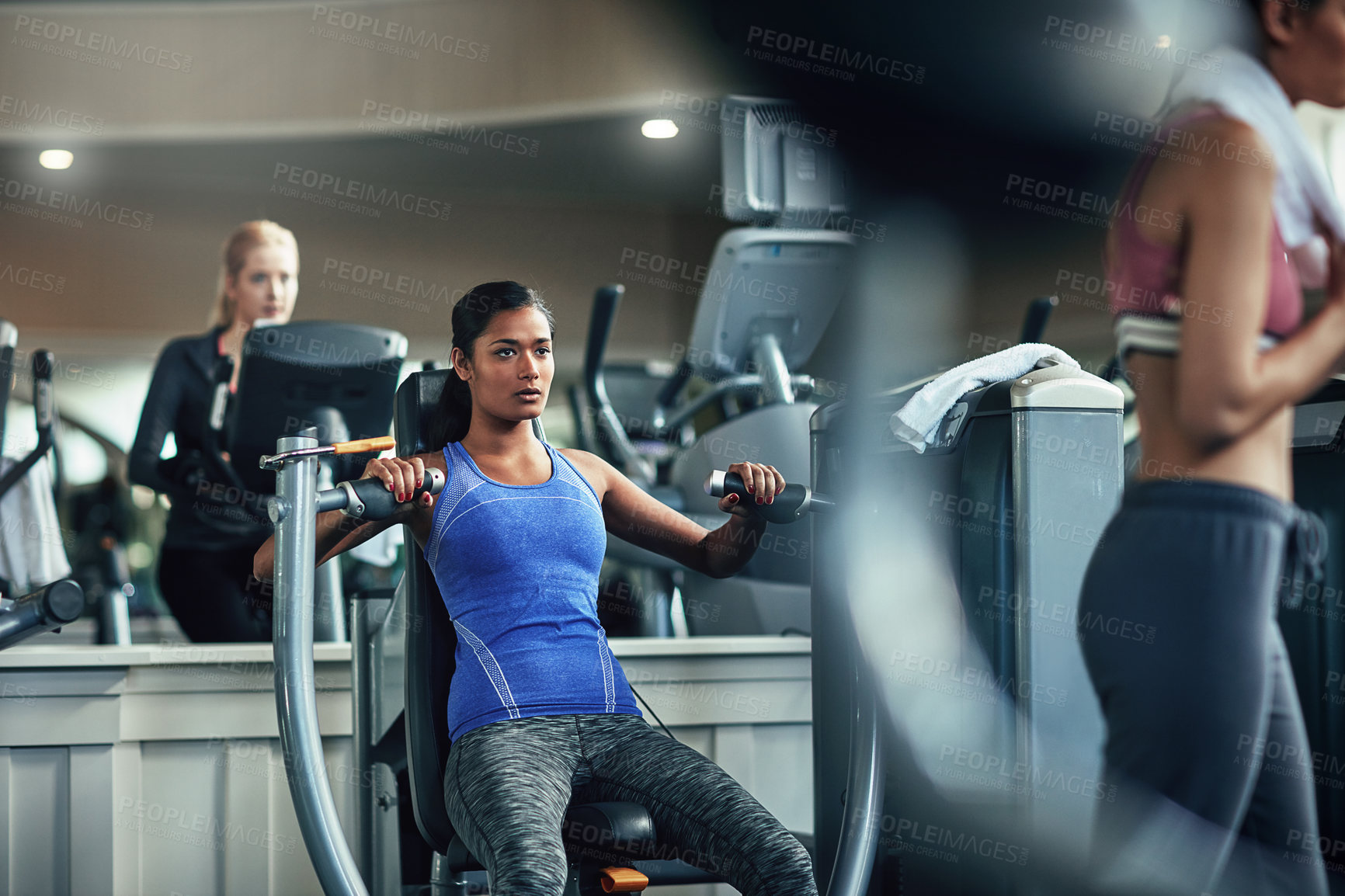 Buy stock photo Shot of a young woman working out with a chest press at a gym