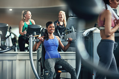 Buy stock photo Shot of a young woman working out with a chest press at a gym