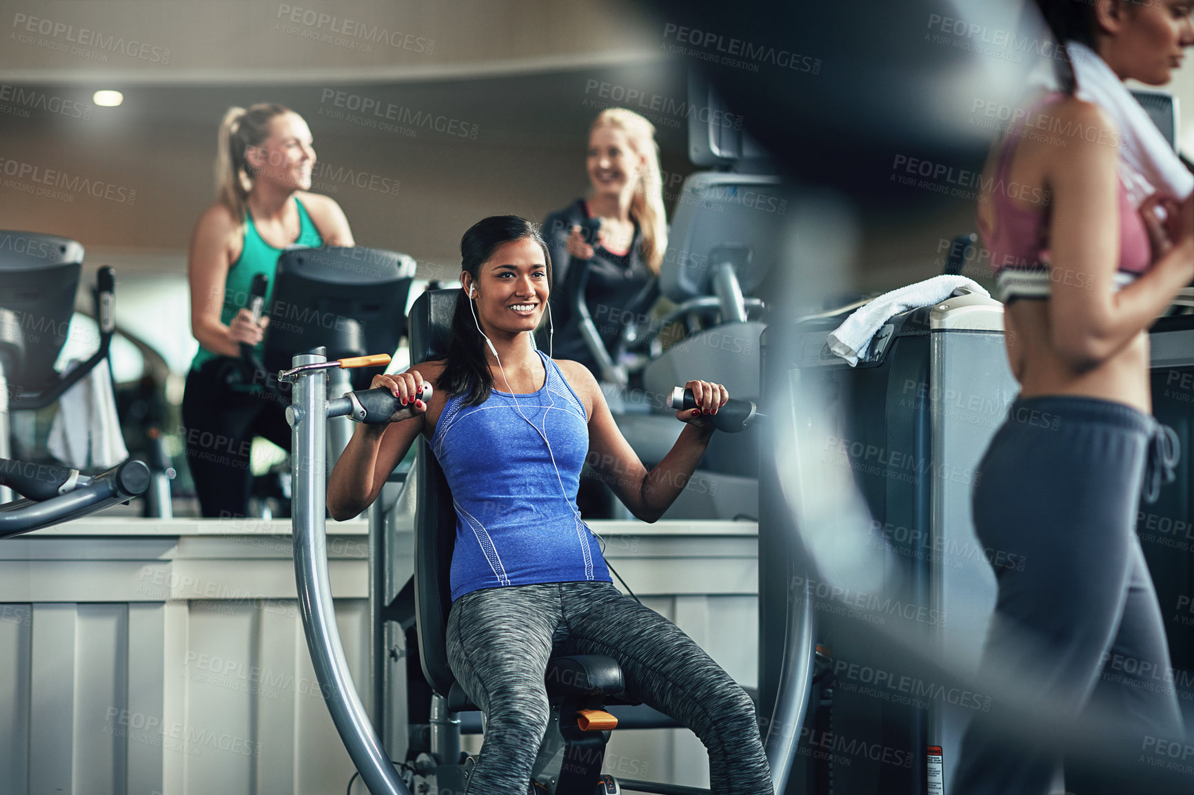 Buy stock photo Shot of a young woman working out with a chest press at a gym