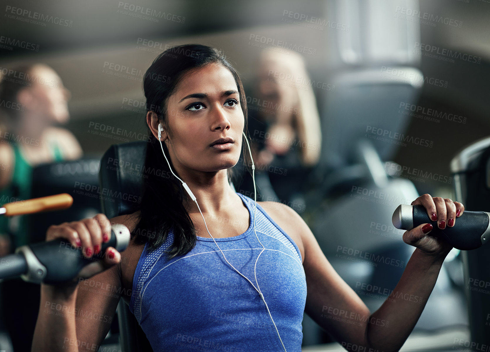 Buy stock photo Shot of a young woman working out with a chest press at a gym