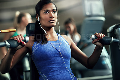 Buy stock photo Shot of a young woman working out with a chest press at a gym