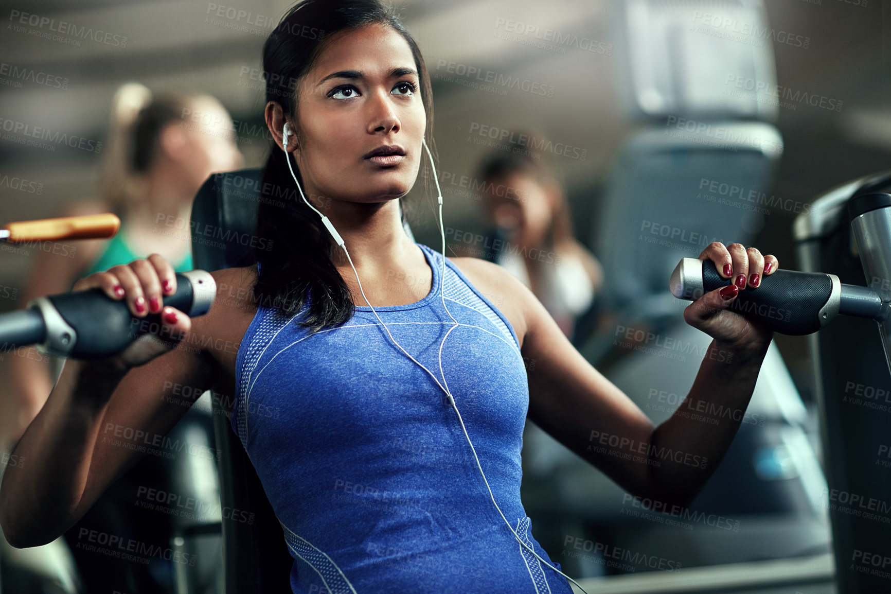 Buy stock photo Shot of a young woman working out with a chest press at a gym