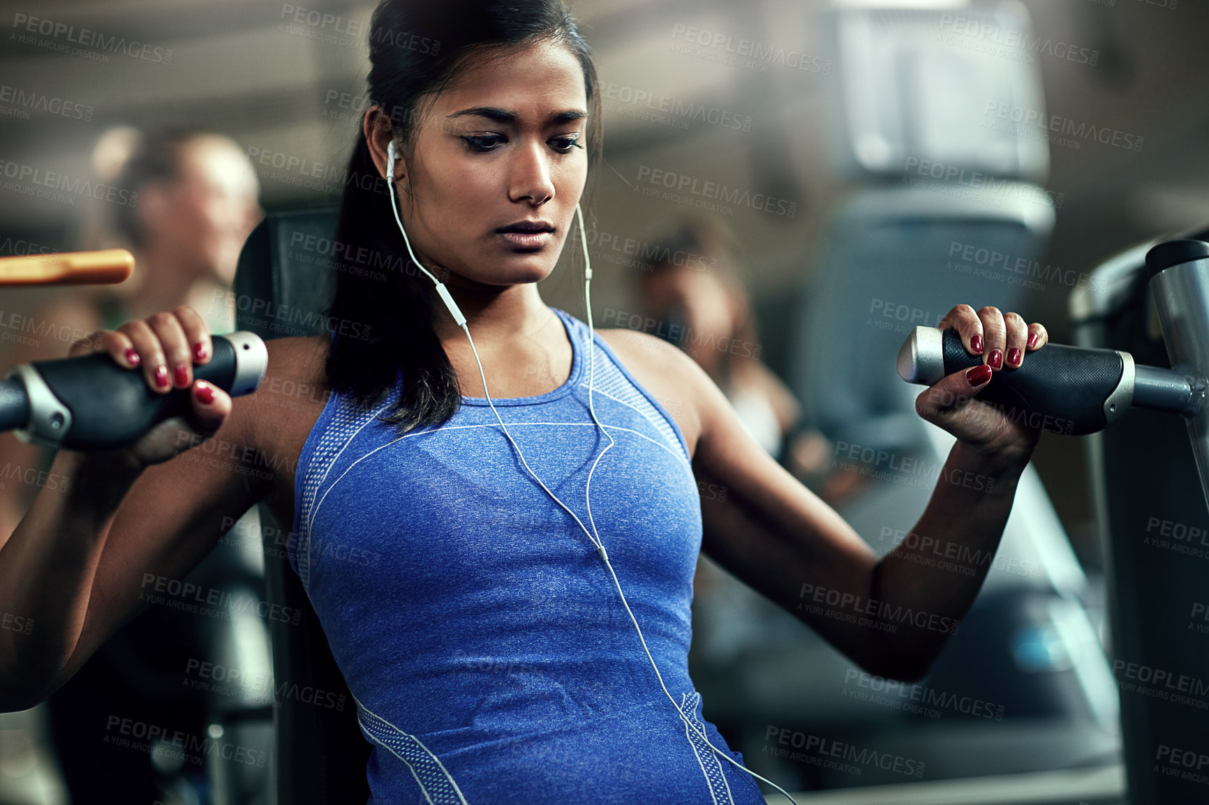 Buy stock photo Shot of a young woman working out with a chest press at a gym