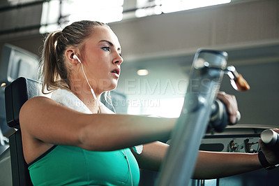 Buy stock photo Shot of a young woman working out with a chest press at a gym