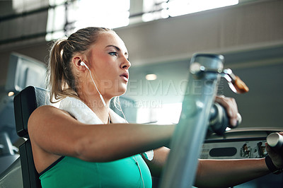 Buy stock photo Shot of a young woman working out with a chest press at a gym