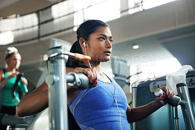 Buy stock photo Shot of a young woman working out with a chest press at a gym