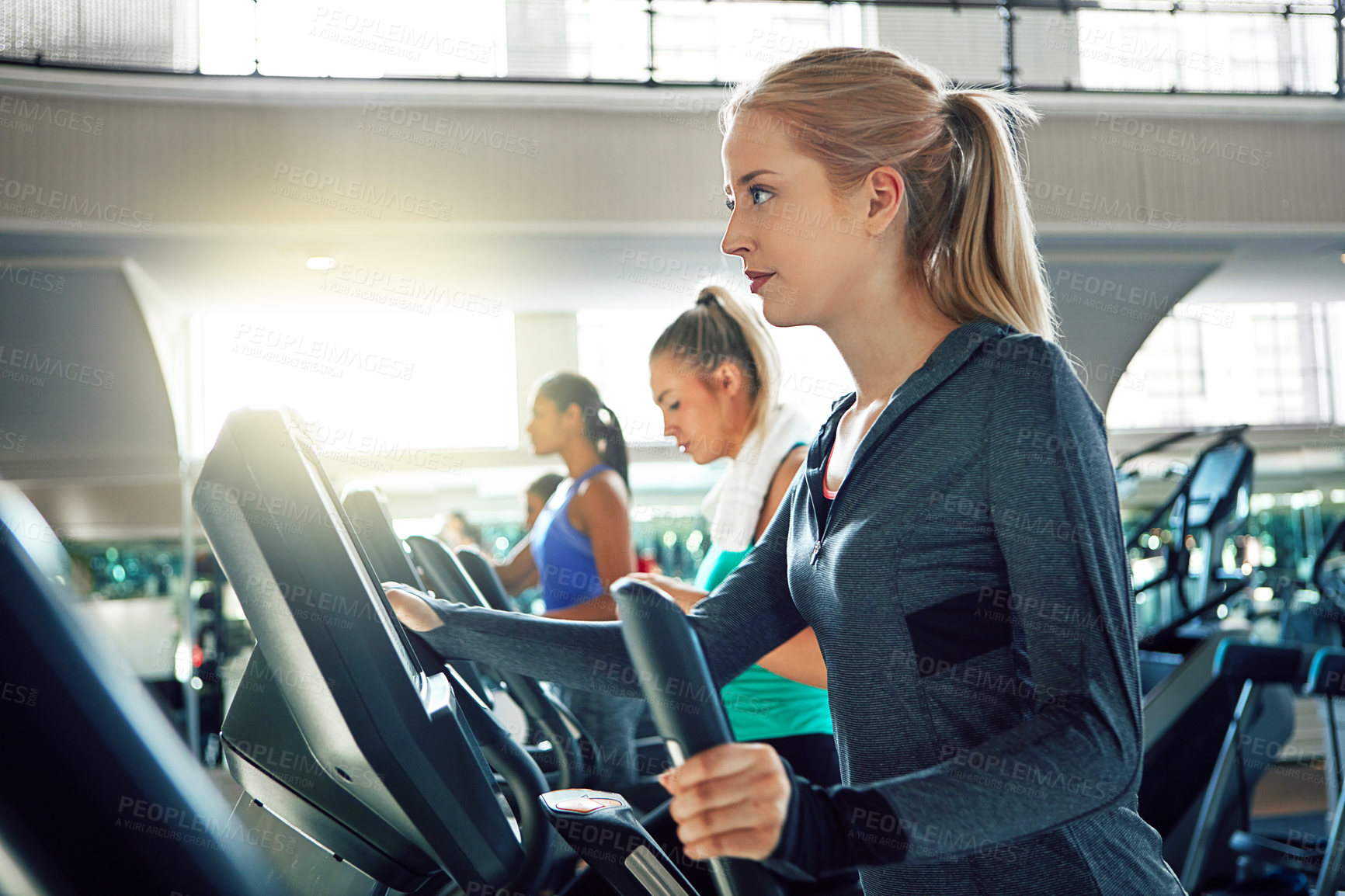 Buy stock photo Shot of a young woman working out with a machine at a gym