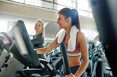 Buy stock photo Shot of a young woman working out with a machine at a gym