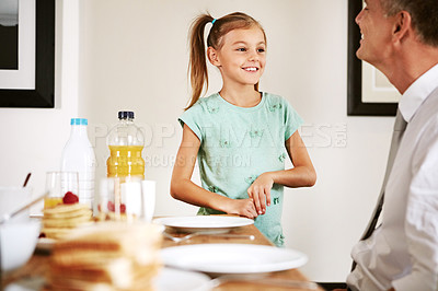 Buy stock photo Shot of a little girl bonding with her father at the breakfast table
