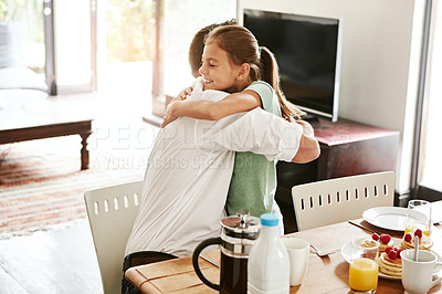 Buy stock photo Shot of a little girl hugging her father at the breakfast table