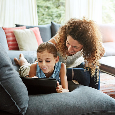 Buy stock photo Shot of a mother and her little daughter using a digital tablet together at home