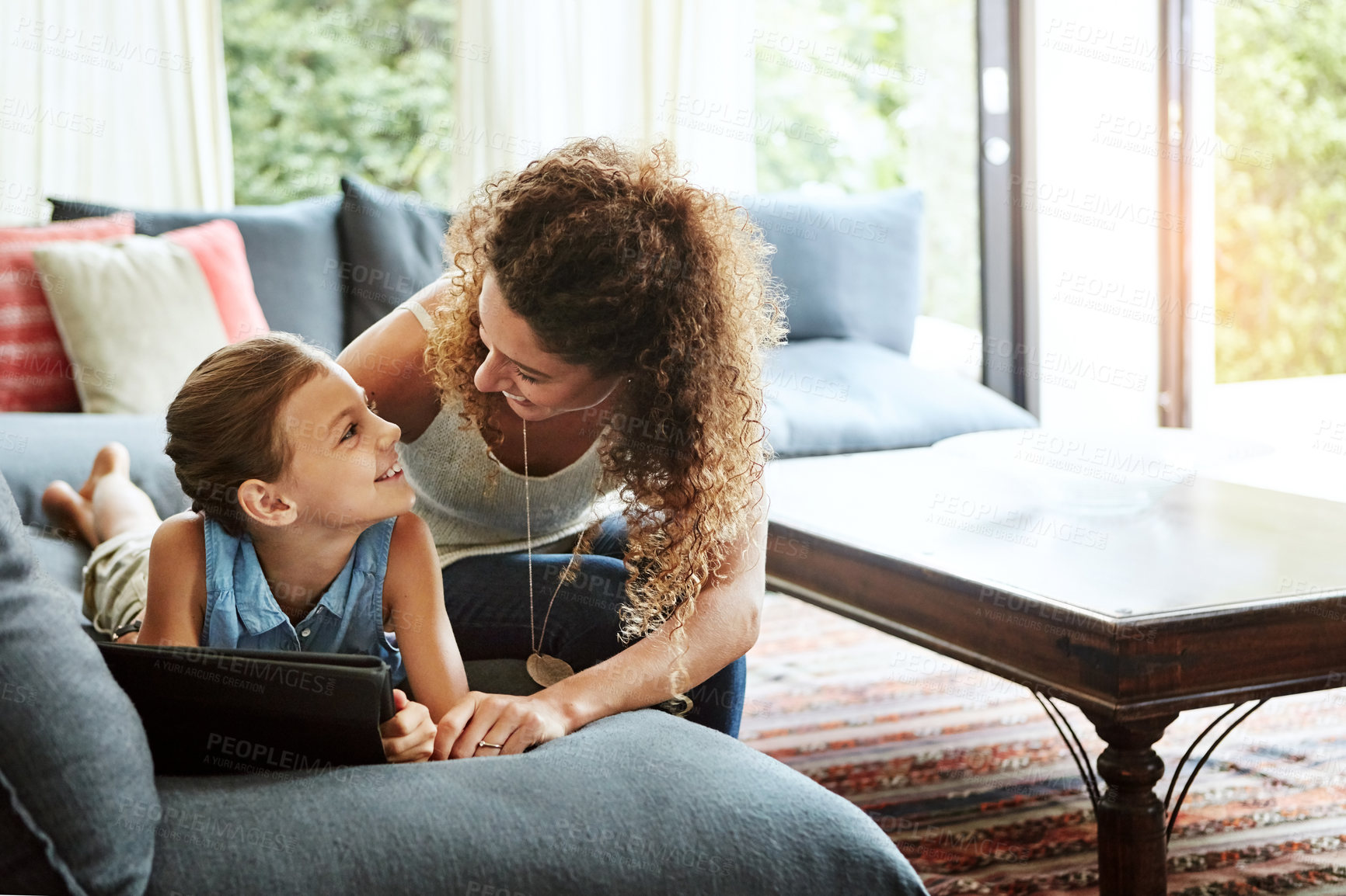 Buy stock photo Shot of a mother and her little daughter using a digital tablet together at home