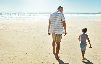 Buy stock photo Shot of a father enjoying some quality time with his little son at the beach