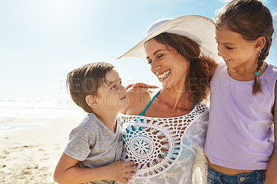 Buy stock photo Shot of a mother and her two little children enjoying some quality time together at the beach