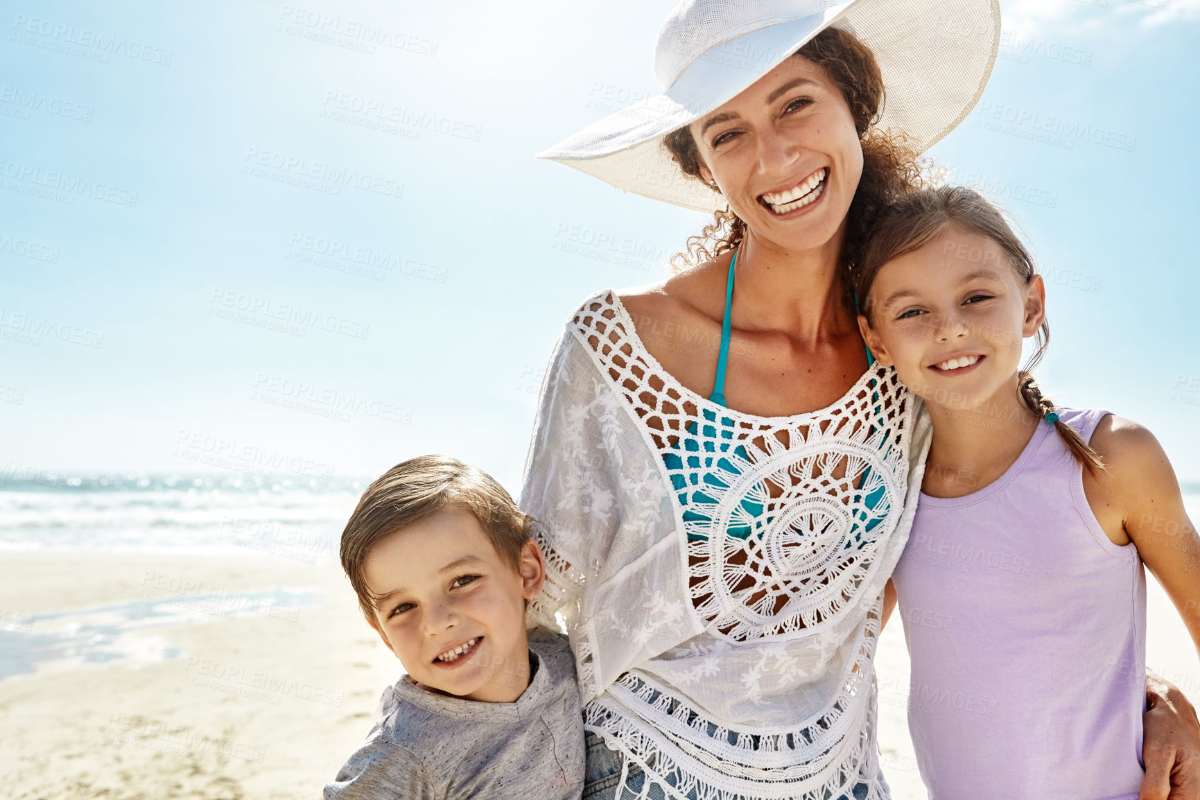 Buy stock photo Portrait of a mother and her two little children enjoying some quality time together at the beach
