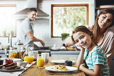 Buy stock photo Shot of a little girl having breakfast with her parents at home