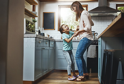 Buy stock photo Shot of a mother playing with her little daughter in the kitchen at home