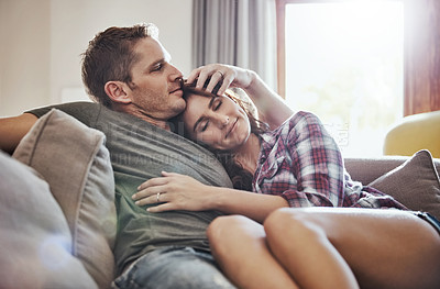 Buy stock photo Shot of a young couple relaxing together on the sofa at home