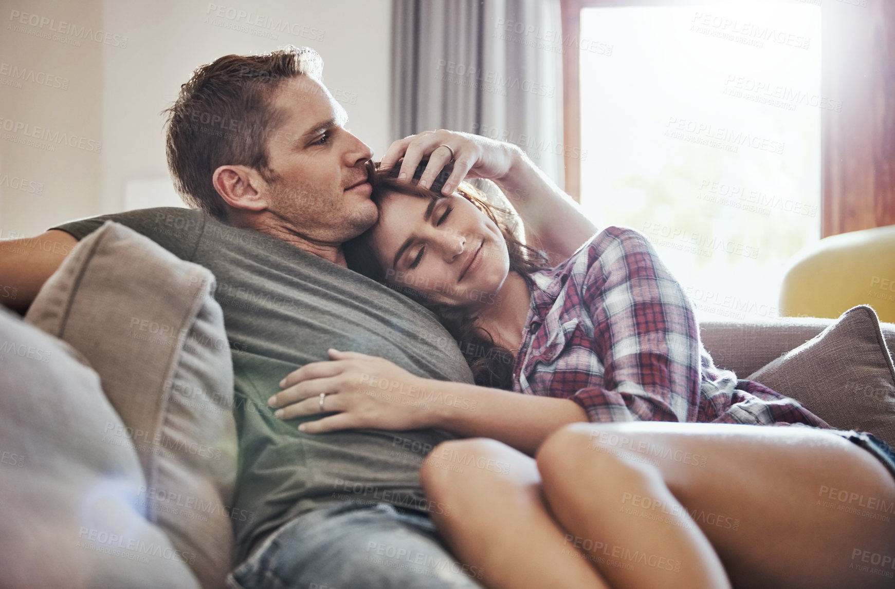 Buy stock photo Home, relax and couple on sofa with hug for commitment, support and bonding together in marriage. Calm, peace and man with affection to woman in living room for happiness, comfort and care on weekend