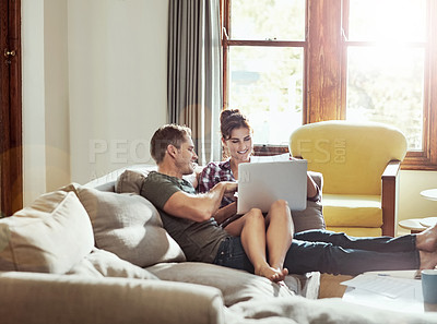 Buy stock photo Shot of a young couple using a laptop together on the sofa at home