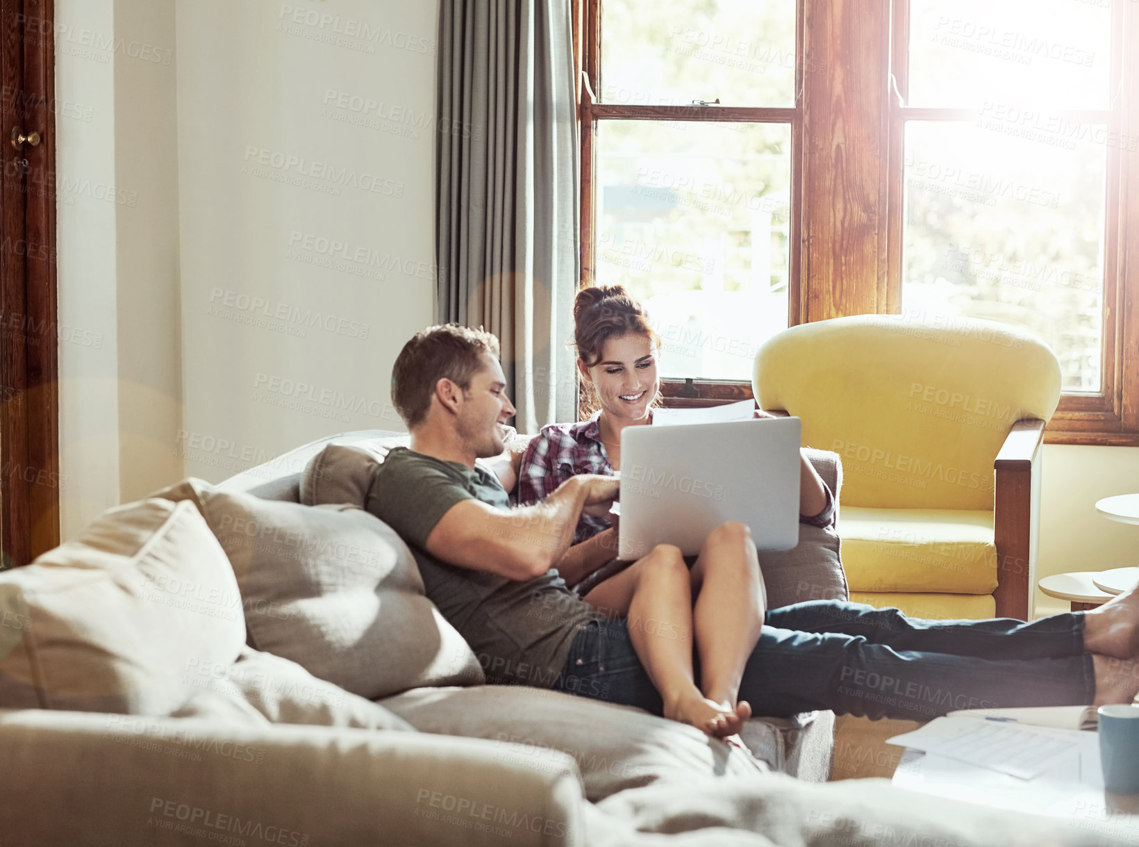 Buy stock photo Shot of a young couple using a laptop together on the sofa at home