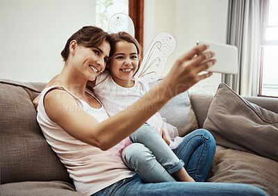 Buy stock photo Mom, girl and happy on selfie on sofa for memories, fun and care with support for child development. Family, people and smile in living room on couch for social media, bonding and home with butterfly