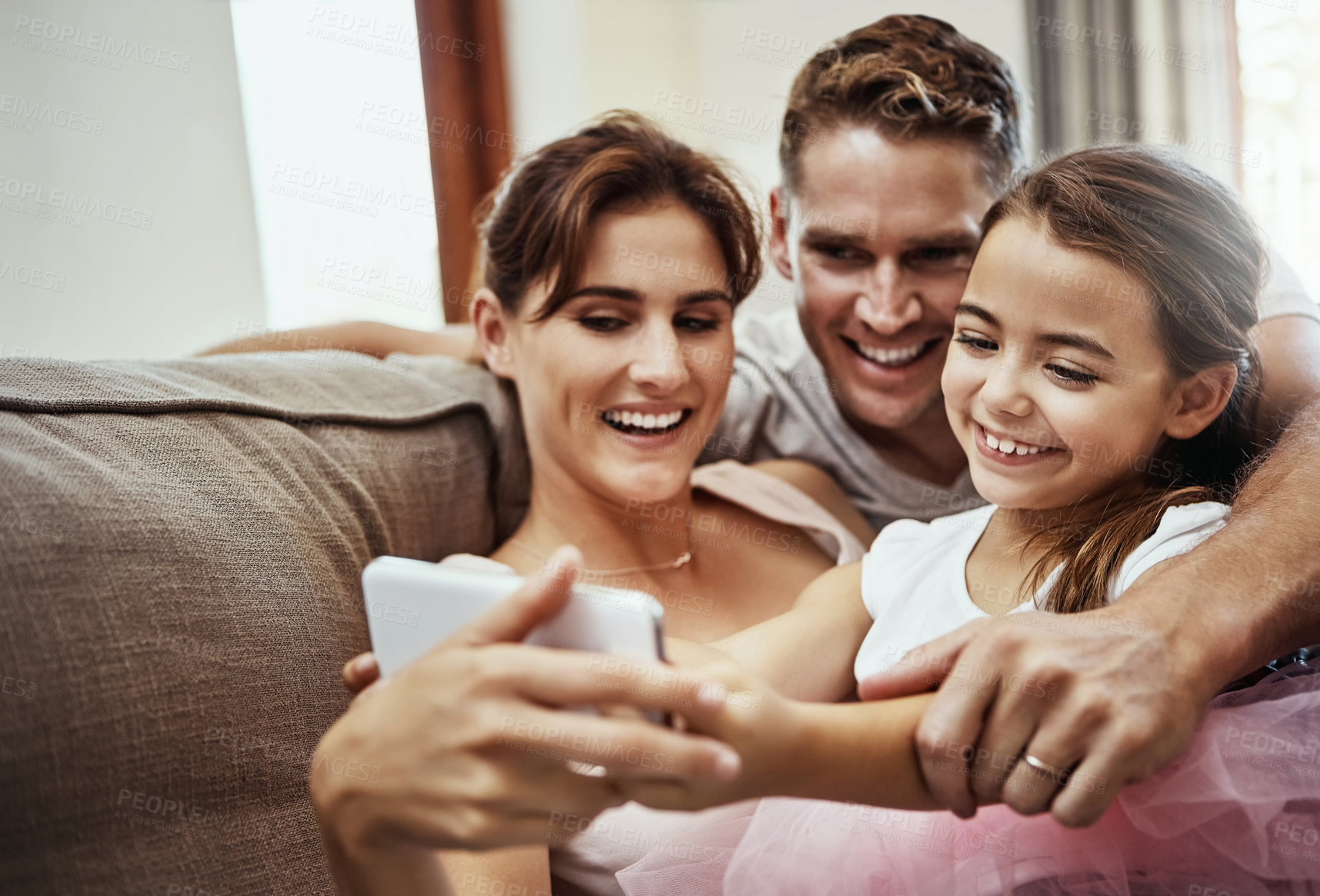 Buy stock photo Shot of a little girl taking a selfie with her parents at home