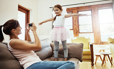 Buy stock photo Shot of a mother taking a photo of her little daughter having fun at home