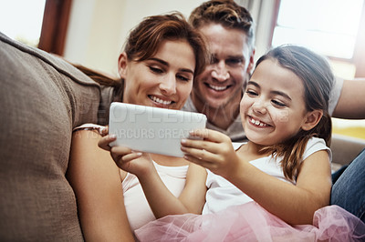 Buy stock photo Shot of a little girl taking a selfie with her parents at home
