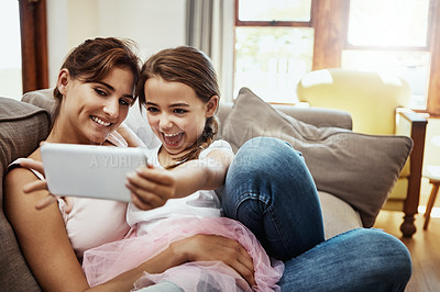Buy stock photo Shot of a little girl taking a selfie with her mother at home