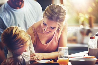 Buy stock photo Shot of a woman sitting with her son while he's having breakfast