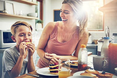 Buy stock photo Shot of a woman sitting with her son while he's having breakfast