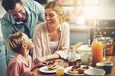 Buy stock photo Cropped shot of a little boy eating breakfast with his parents