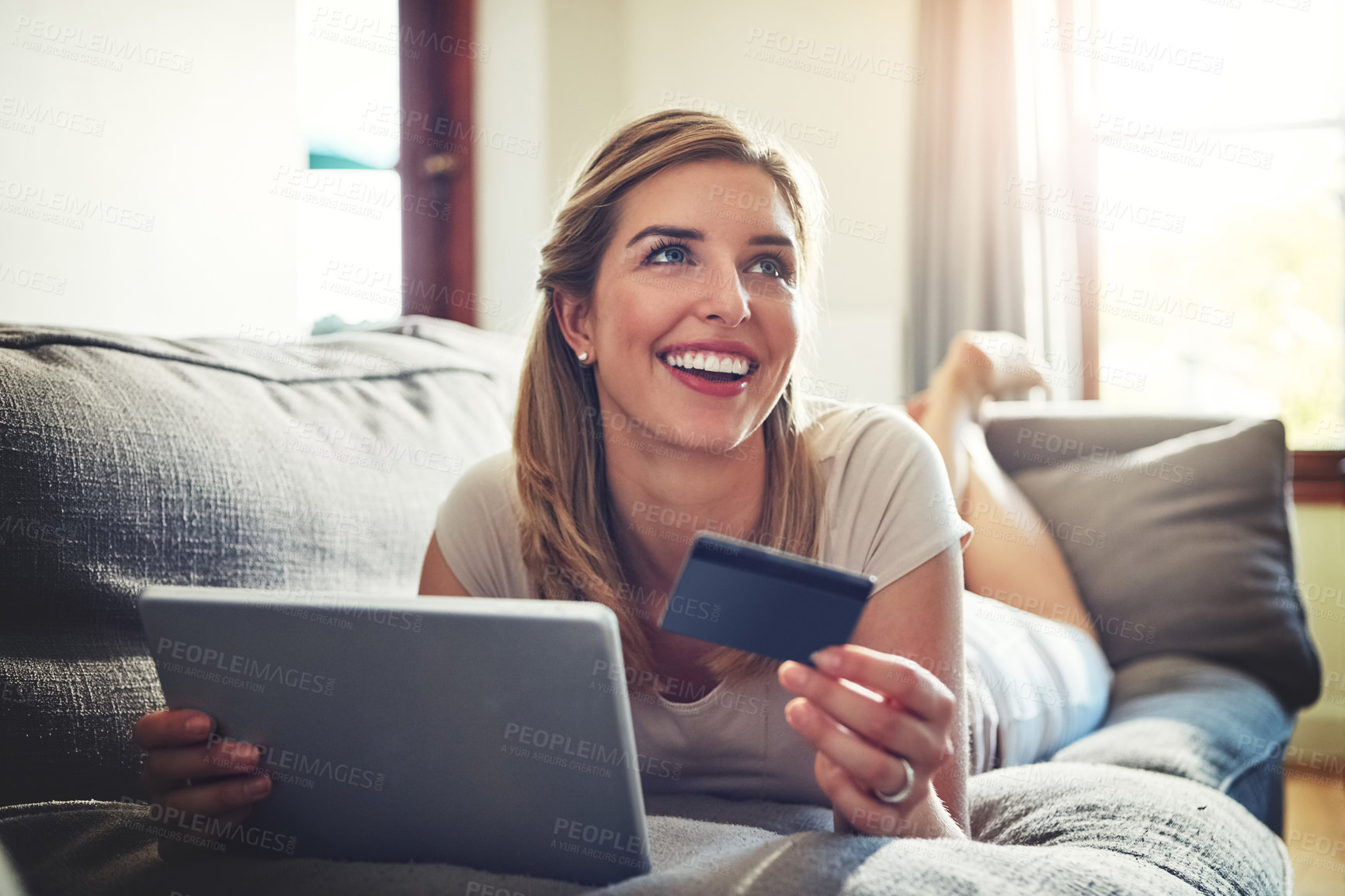 Buy stock photo Shot of a young woman doing some online shopping on her digital tablet