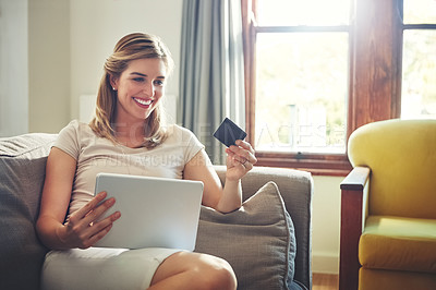 Buy stock photo Shot of a young woman doing some online shopping on her digital tablet