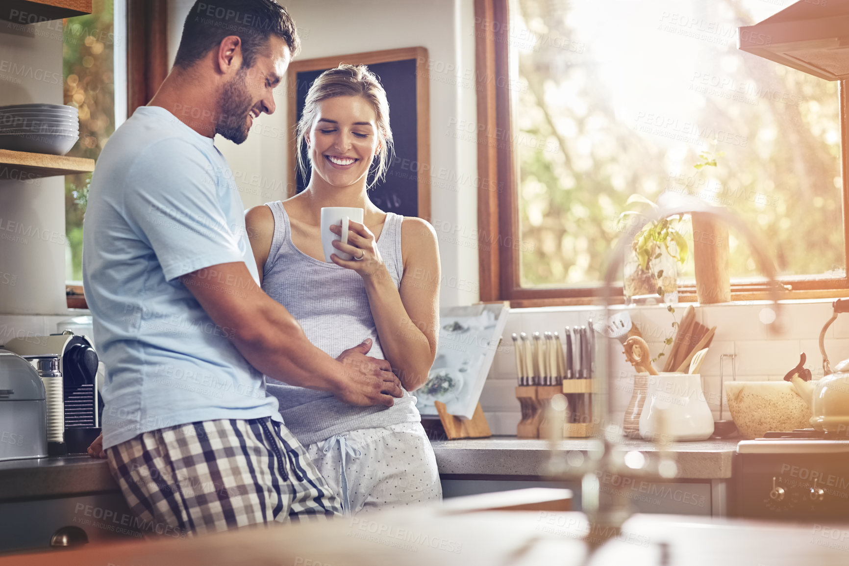 Buy stock photo Coffee, hug and love with couple in kitchen of home together for morning break or wellness. Embrace, smile or tea with happy man and woman drinking fresh beverage in apartment to relax for romance