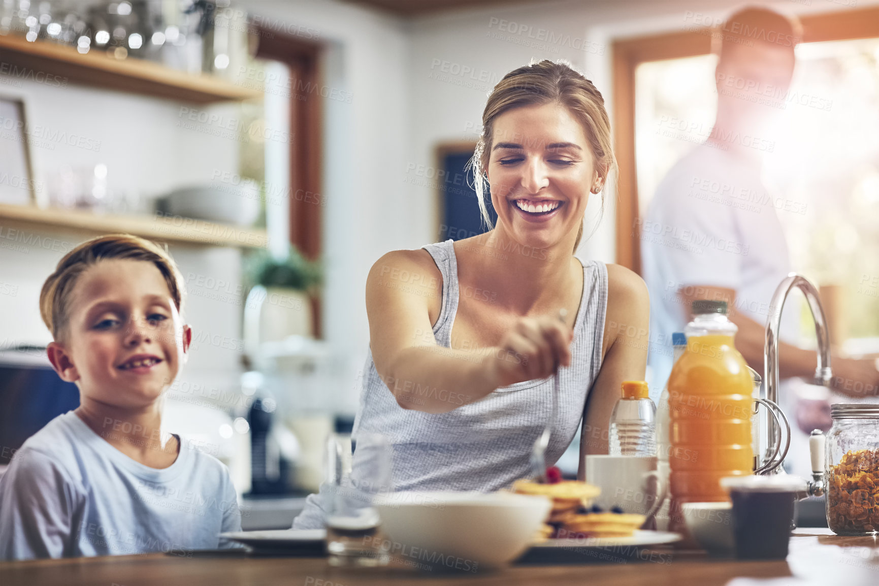 Buy stock photo Shot of a woman sitting with her son while he's having breakfast