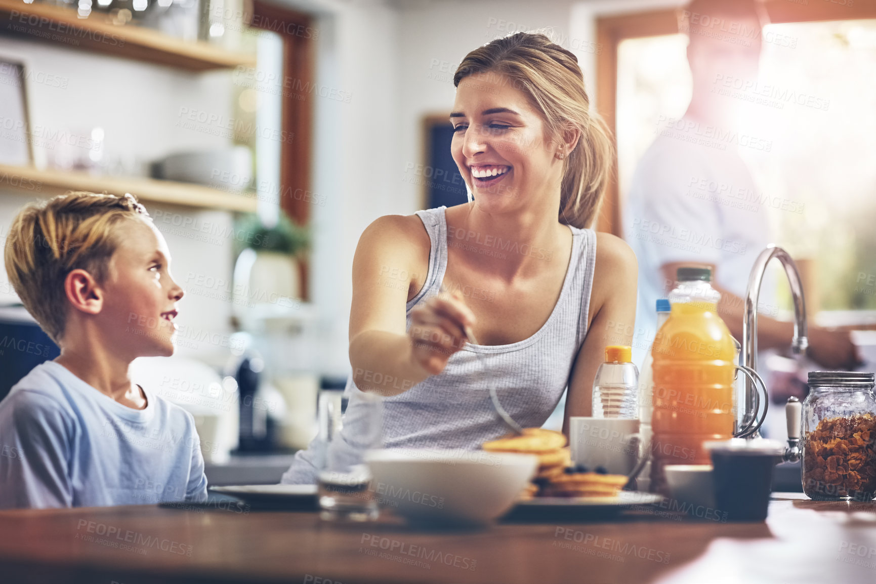 Buy stock photo Shot of a woman sitting with her son while he's having breakfast